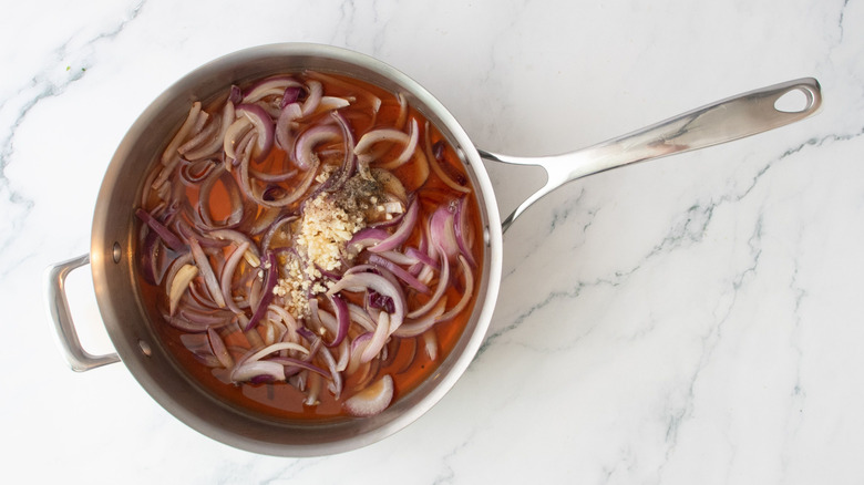 Red wine onions with garlic in saucepan