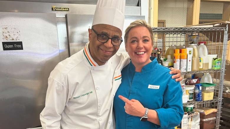 Julia Collin Davison smiling and pointing at Chef Coppedge