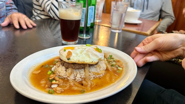 Loco moco dish next to a nitro cold brew on restaurant table.