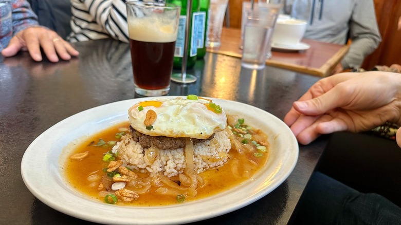 Loco moco dish next to a nitro cold brew on restaurant table.