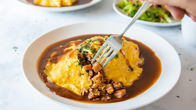omurice with spam being cut into with fork