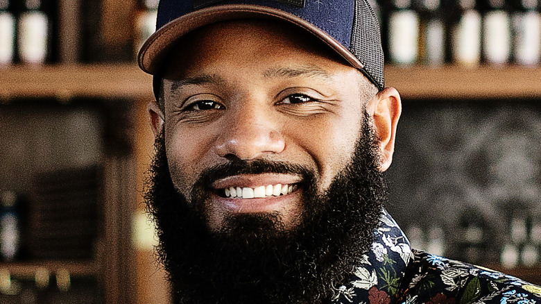 Justin Sutherland smiling and wearing hat