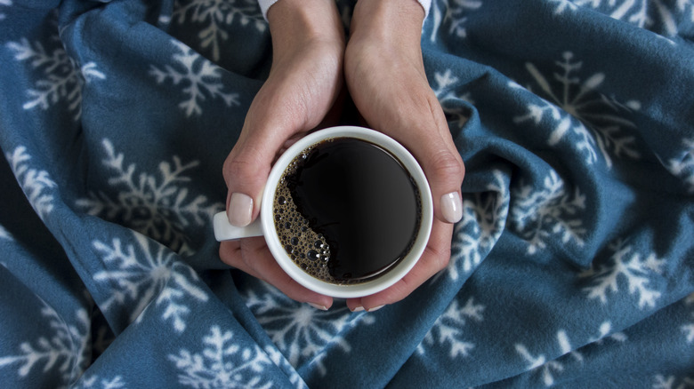 Person holding mug of coffee