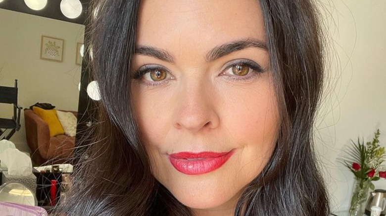 katie lee beigel smiling in bold lipstick