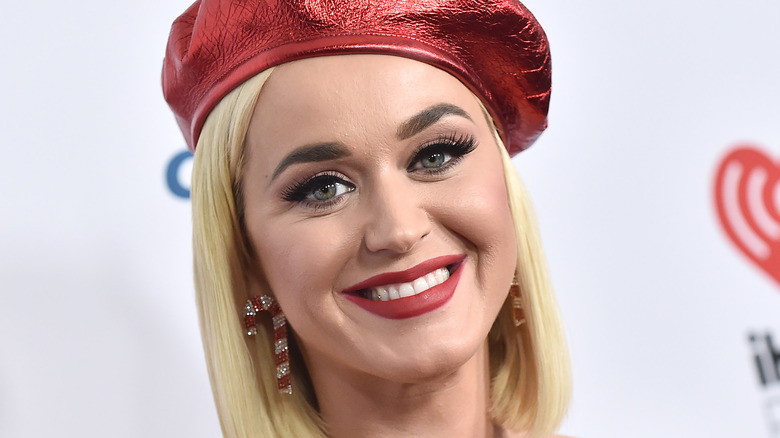 Katy Perry blond with earrings and a red hat