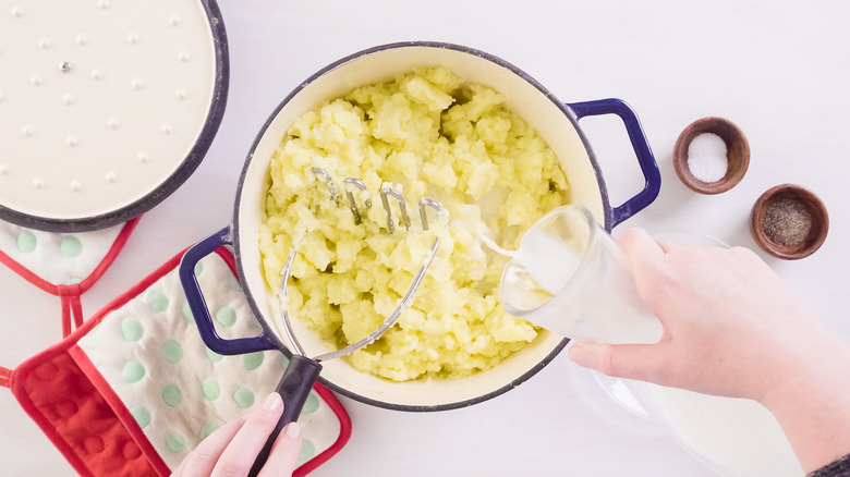 pouring cream in mashed potatoes