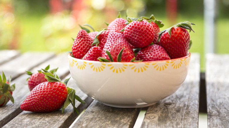 Bowl of fresh strawberries on outdoor table