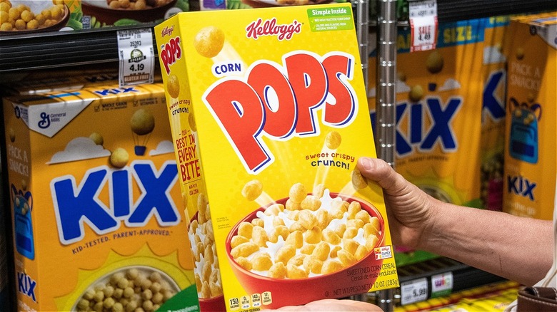 Hand holding a box of Corn Pops cereal