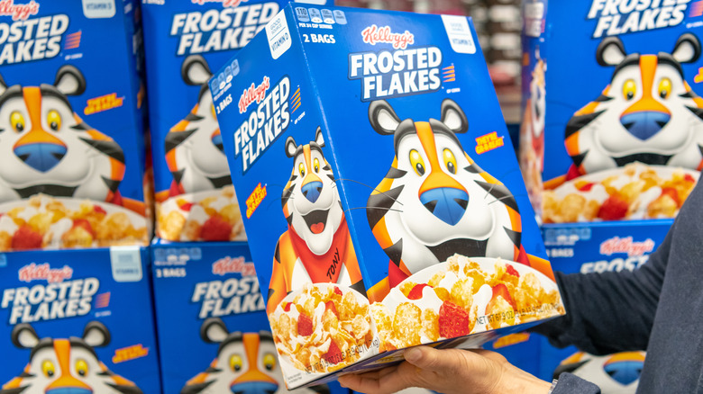 customer holds box of frosted flakes
