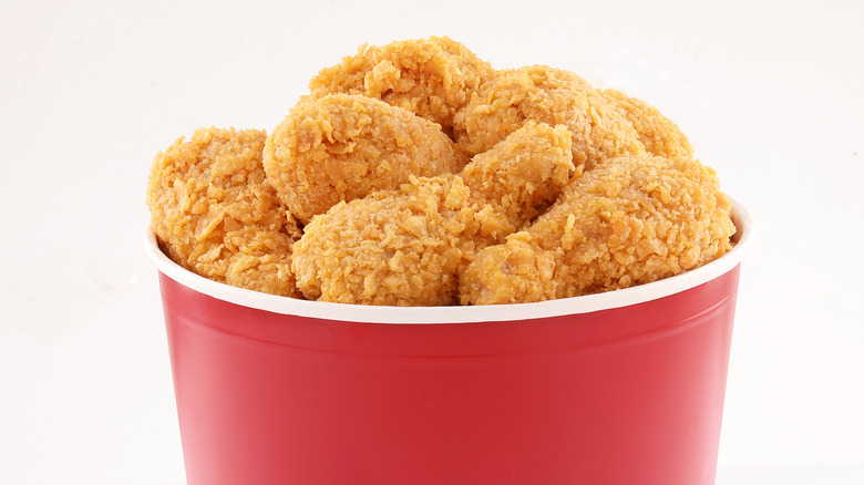 Red bucket of fried chicken on white background