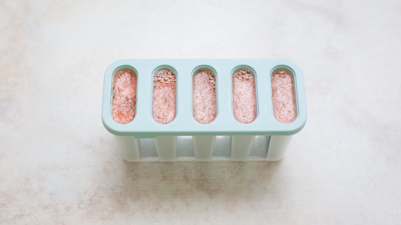 filled popsicle molds on table