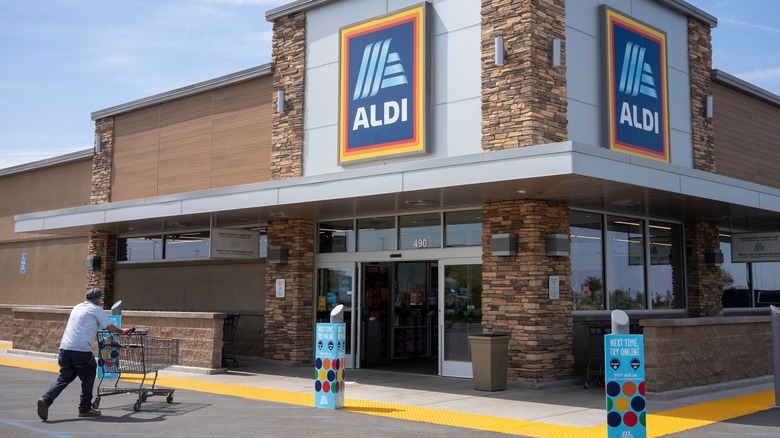 Shopper entering Aldi with cart