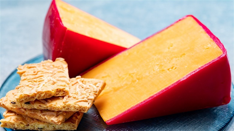 Two wedges of sharp cheddar and crackers