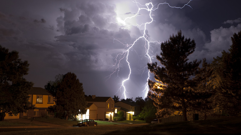 Lightning striking above suburban home