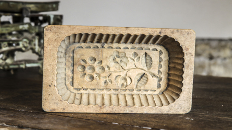 Carved wooden butter mold on wood table