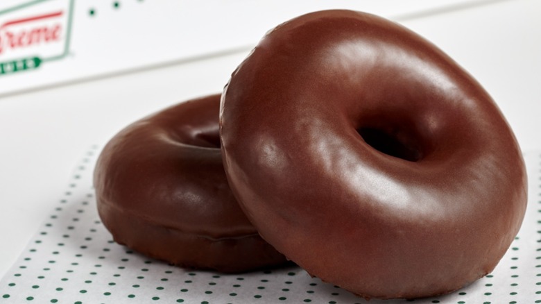 Two chocolate glazed Krispy Kreme doughnuts