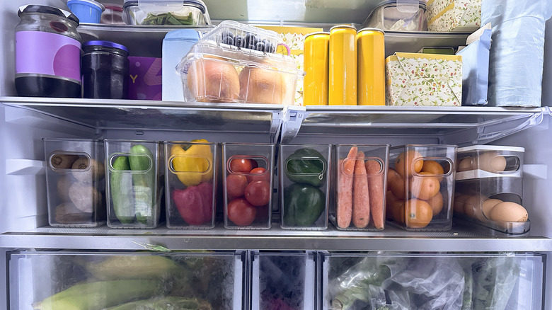 Interior of a refrigerator with vegetables, jarred foods, and other items.