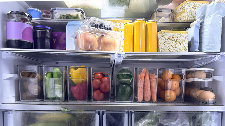 Interior of a refrigerator with vegetables, jarred foods, and other items.