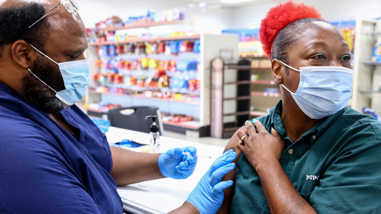 Pharmacy worker giving COVID-19 shot