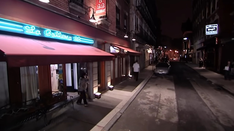 The exterior of La Galleria 33 with a red awning and neon sign at night in Boston, Massachusetts