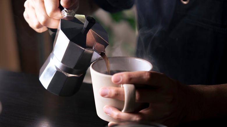 man pouring coffee into mug