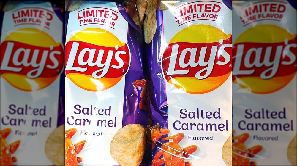 Two bags of Lays Salted Caramel chips, bags are purple with text "Limited Time Flavor," they have a picture of a candy caramel drizzled in caramel and salt and a potato chip on them.