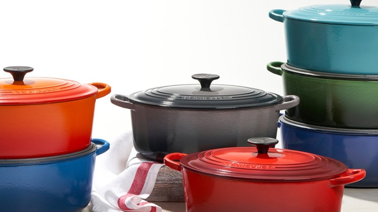 A group of seven Le Creuset Dutch ovens, some stacked