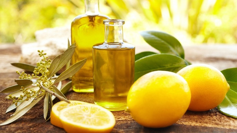 Jars of lemon oil next to lemons