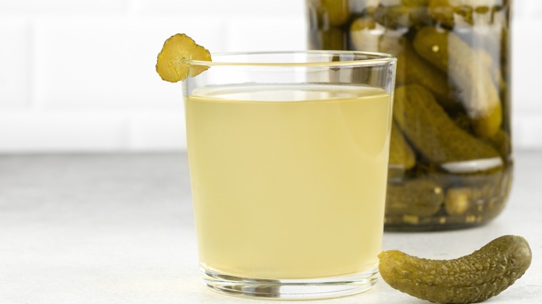 Pickle juice in a glass with picklee garnish