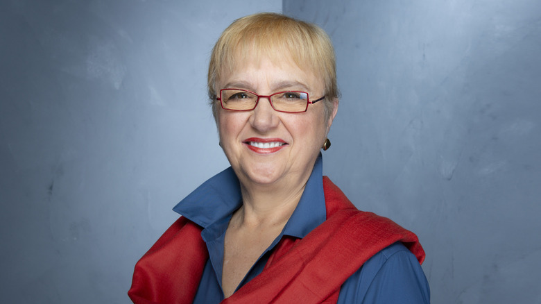 Chef Lidia Bastianich smiling and wearing a red scarf