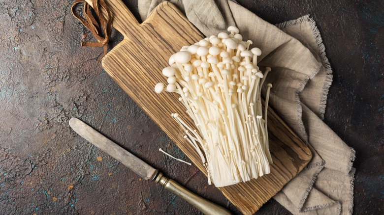 Enoki mushrooms on wooden board