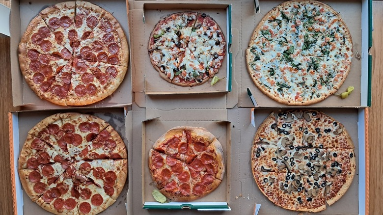 six pizzas in open boxes