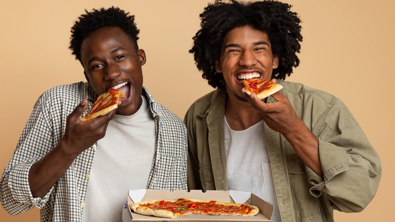 young men eating pizza