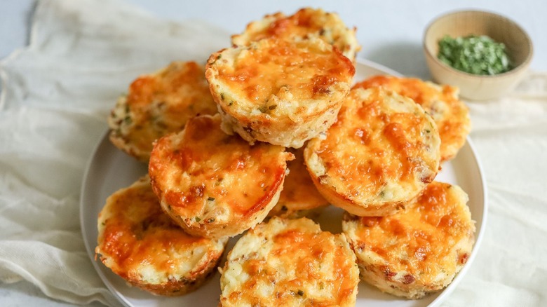 Cheesy mashed potato cups stacked onto plate