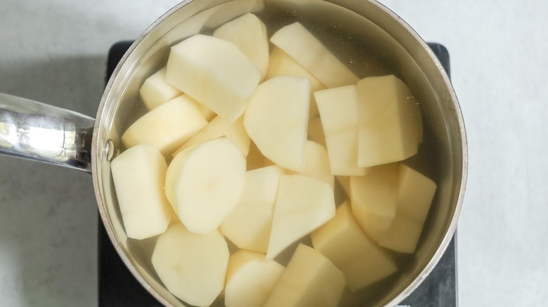 sliced potato chunks in pot of water