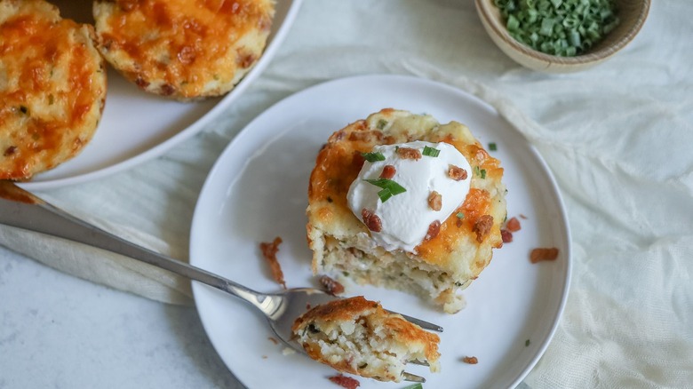 Loaded mashed potato cup on a plate with fork