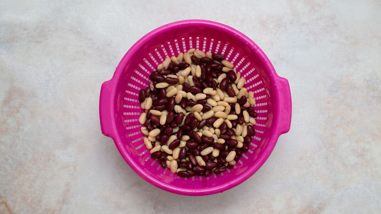 mixed beans in pink colander