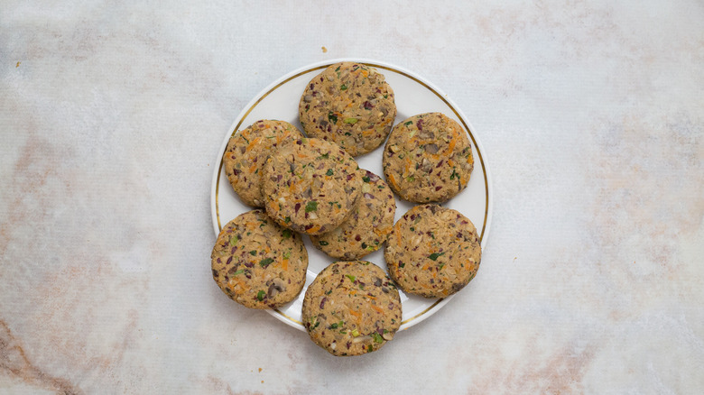 raw veggie burgers on plate