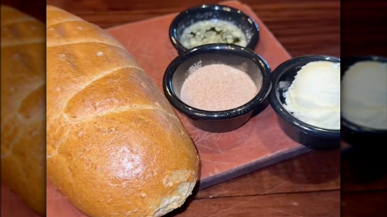 LongHorn Steakhouse bread on a cutting board with butter and cinnamon sugar