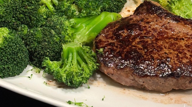 A LongHorn Steakhouse steak with a side of broccoli.