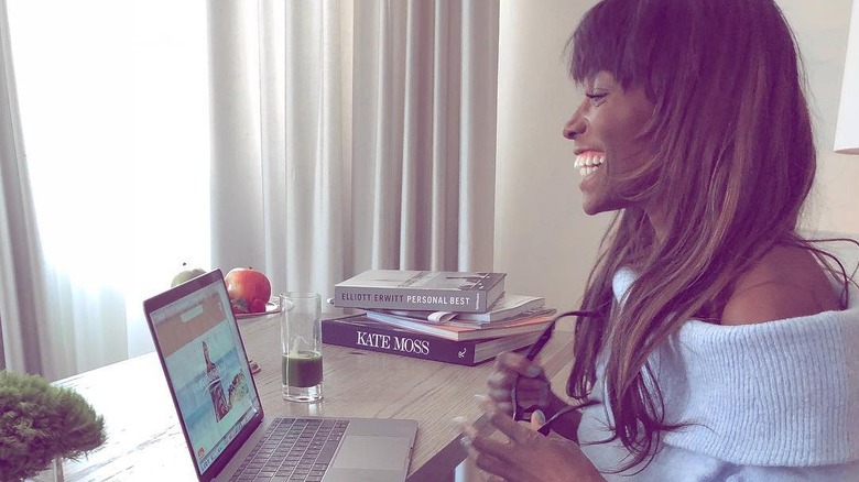 Lorraine Pascale sitting before a desk with an open laptop and books on top