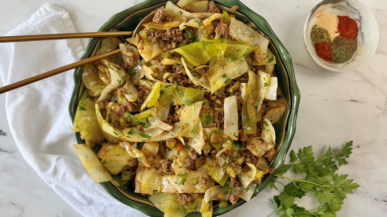 Dirty cabbage in bowl next to herbs and small bowl of spices