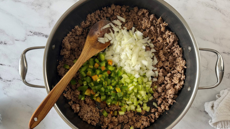 Ground meat in skillet with onion, celery, and bell pepper