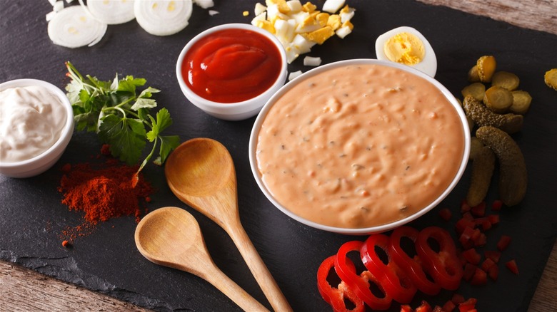 Thousand Island dressing displayed with its base ingredients, including ketchup and mayonnaise.