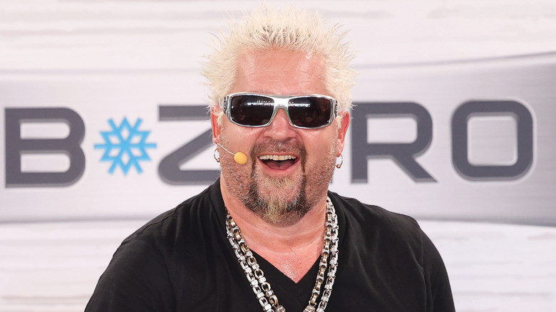 Guy Fieri in sunglasses and headset, smiling