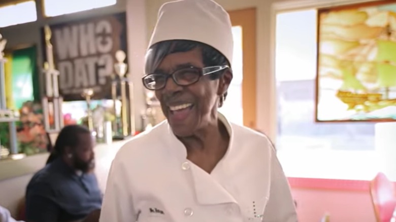 Alice Harper in cook's jacket and white hat, smiling