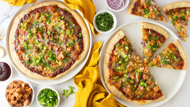 two pizzas topped with chicken and green onions
