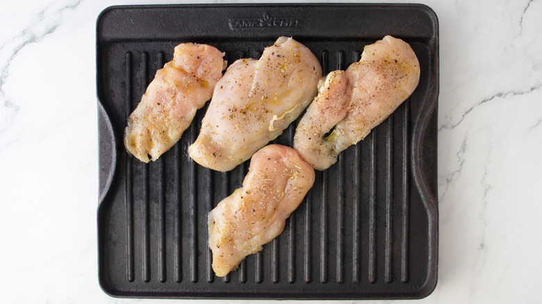 raw chicken on a stovetop grill pan