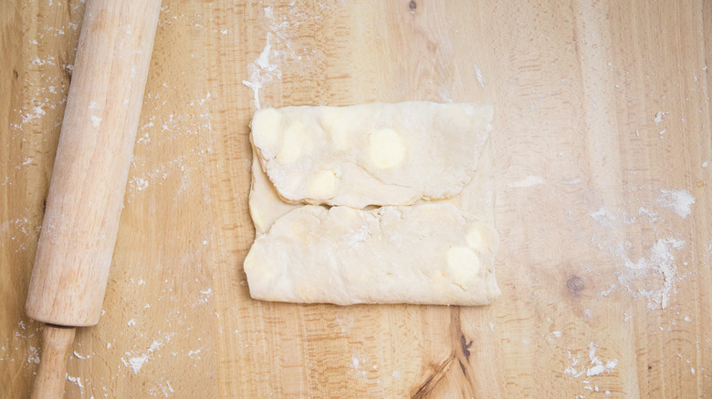 folded dough on wooden table