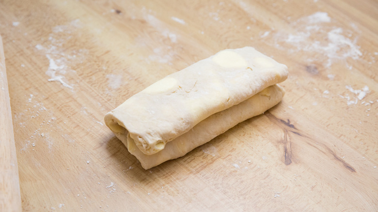 folded dough on wooden table